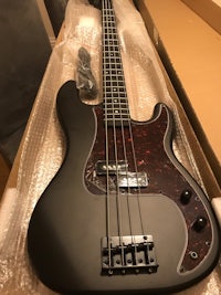 a black bass guitar sitting in a box