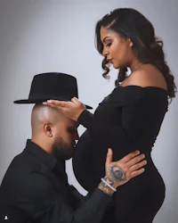 a pregnant woman with a hat on her head and a man with a hat on his head