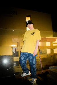 a man in a yellow t - shirt standing on a wooden platform