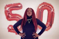 a woman posing in front of balloons with the word 50