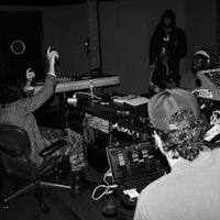 a black and white photo of a group of people in a recording studio