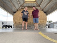 two people standing on top of a large wicker basket