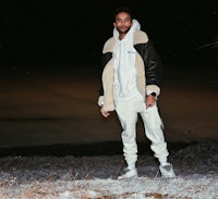 a man in a white jacket standing in the snow
