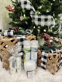 a basket of bath and body products next to a christmas tree