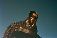 a woman wearing a cloak and a mask