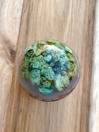 a blue and green stone sphere sitting on a wooden table
