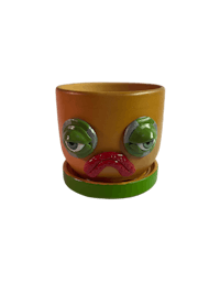 a yellow and green planter with a face on it