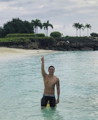 a man standing in the water with a surfboard