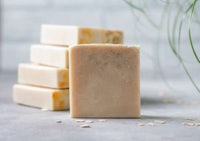 a stack of soap with oats and a plant on top
