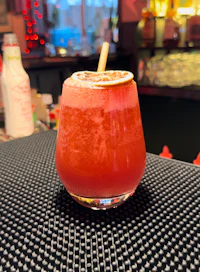 a drink with a straw sitting on top of a bar