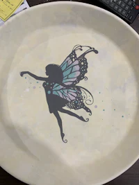 a plate with a fairy silhouette on it