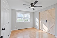 an empty room with wood floors and a ceiling fan