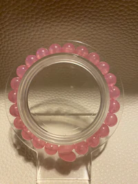 a pink bead holder on a white wall