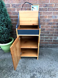 a small wooden cabinet with a potted plant on it