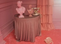 a pink room with statues and a telephone