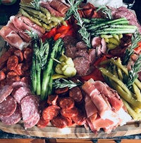 a platter of meats and vegetables on a table