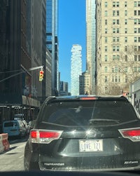 a black suv driving down a city street