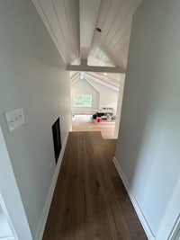 a hallway with white walls and wood floors