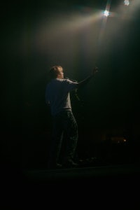 a man standing on a stage with a light shining on him