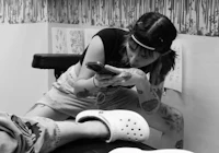 a woman is getting tattooed on her foot