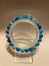 a blue and white bead bracelet on a clear holder