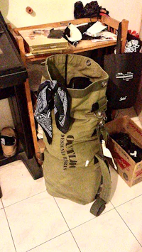a green bag sitting on a tile floor