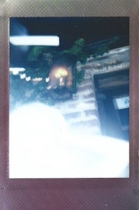 a polaroid picture of a building with a tree in the background