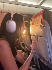 a woman wearing headphones on an airplane