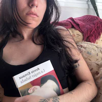 a woman sitting on a couch holding a book
