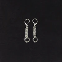 a pair of silver earrings on a black background