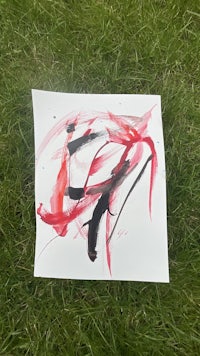 a piece of paper with red and black paint on it