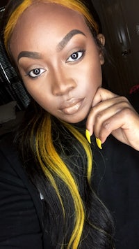 a black woman with yellow and black hair is posing for a photo