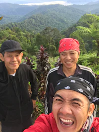 three men taking a selfie on top of a mountain