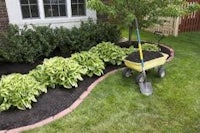 a wheelbarrow with a wheelbarrow in front of a house