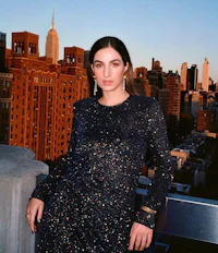 a woman in a blue dress posing on a rooftop