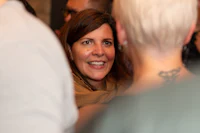 a woman smiling at a crowd of people