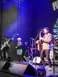 a group of people on stage with a saxophone
