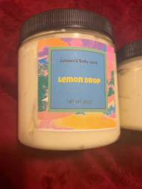 two jars of lemon drop soap on a red cloth