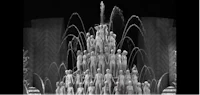 a black and white photo of a fountain with people in it