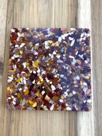 a colorful stone coaster on a wooden table