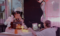 a man and woman sitting at a table with a laptop