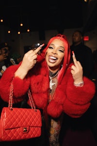 a woman in a red fur coat is holding a purse