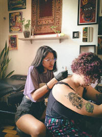 a woman getting a tattoo in a tattoo shop