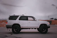 a white toyota savana is parked in a parking lot