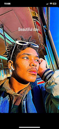 a man wearing a red hoodie standing in front of a suv