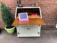 a desk with an ipad and a plant in front of it