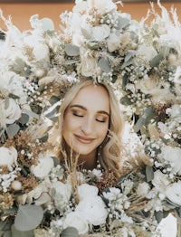 a beautiful bride holding a wreath of flowers