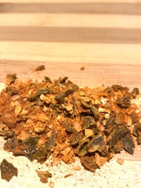 a pile of dried herbs and spices on a wooden board
