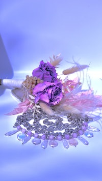 a bouquet of purple flowers and a necklace on a table