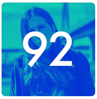 a woman with long hair standing in front of a bridge with the number 92